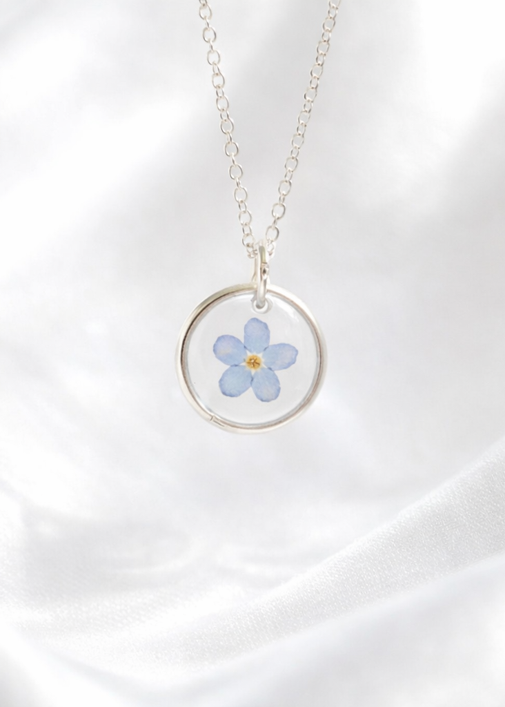 Necklace with a floral pendant on a white fabric background